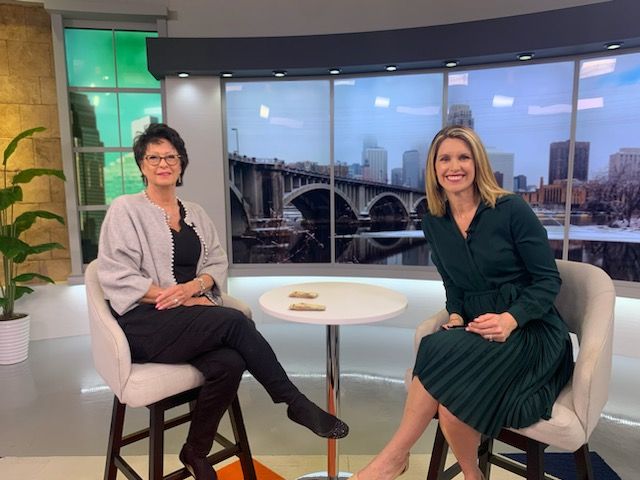 Two women sitting in front of a window on the tv set.